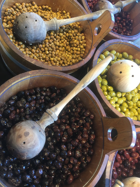 Unterschiedliche Olivensorten in Holzbottichen.